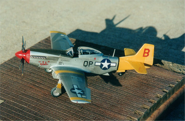 P-51D  QP-B "Julie"
P-51D  QP-B "Julie" was assigned to pilot Capt. Joe M. Randerson of the 2nd Fighter Squadron, 52nd Fighter Group, 306 Fighter Wing, 15th Air Force in Madna, Italy, December 1944.  
 
The aircraft was named after the Crew Chief's sweetheart Miss Julie Curtis who happened to also be the daughter of Major Bob Curtis, the CO of same 2nd Fighter Squadron.
 
Prior to receiving this assigned aircraft, Capt. Randerson had been shot down in a P-51B Mustang  on September 3, 1944.  The P-51B was downed by ground fire while he was straffing a locomotive.
 
Capt. Randerson crashed in a river bed and was severely burned on the arms, legs, and face.  He was rescued by two Serbian farmers. He had his burns tended to for two weeks while he was hidden in a barn, and he was eventually smuggled back to Italy and a hospital where he continued his recovery.  He continued to fly and completed forty-nine combat missions when the war ended in Europe.  He arrived back in Austin on June 19, 1945.
 
Special thanks to Milton Bell for creating the custom decals for this aircraft.
 
Bob King presented the model to Capt. Randerson. Joe Dale Morris, Capt. Randerson's nephew and namesake, also attended the presentation at King's Hobby.

