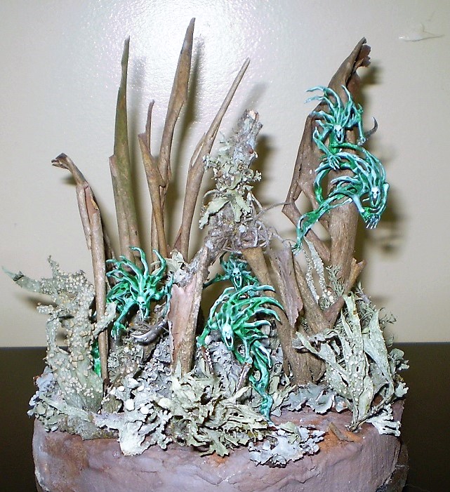Spirit Hosts
These are Spirit Hosts from the Warhammer: Age of Sigmar series. The  
diorama is composed of lichen from pecan trees, bark from a crepe  
myrtle and the odd bit of ball moss. All from the yard. The base is  
florist foam covered in pre- colored tile grout.

